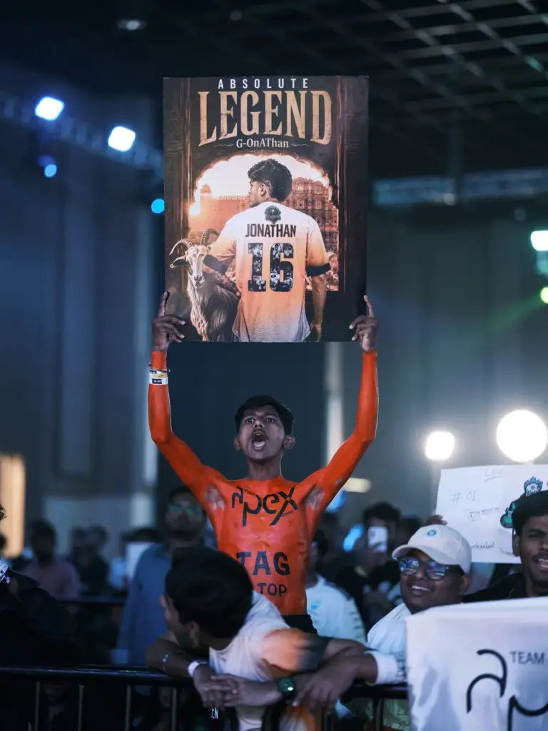 A Team Apex Gaming supporter, painted orange with "TAG" across his chest, holds up an "Absolute Legend" poster of Jonathan. (Image via KRAFTON India)