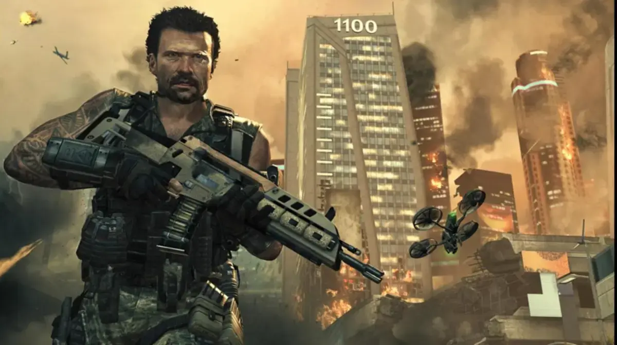 Official Call of Duty: Black Ops II artwork of a soldier holding a rifle in front of burning Los Angeles skyscrapers, with a quad-rotor drone nearby.