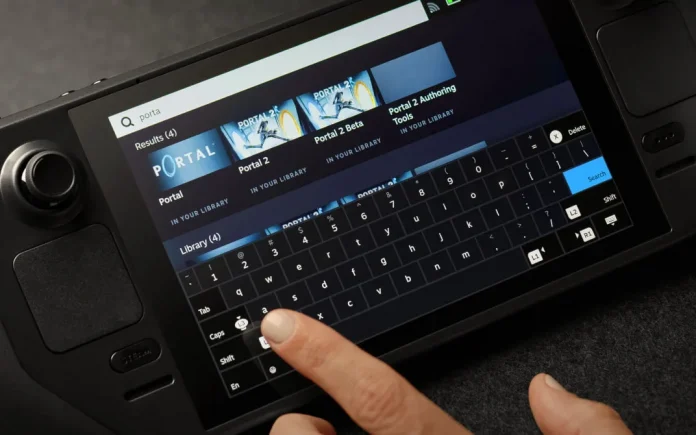 A person using the touchscreen on a Steam Deck to type 'porta' into the Steam search bar, with results showing Portal, Portal 2, Portal 2 Beta, and Portal 2 Authoring Tools all in their library.